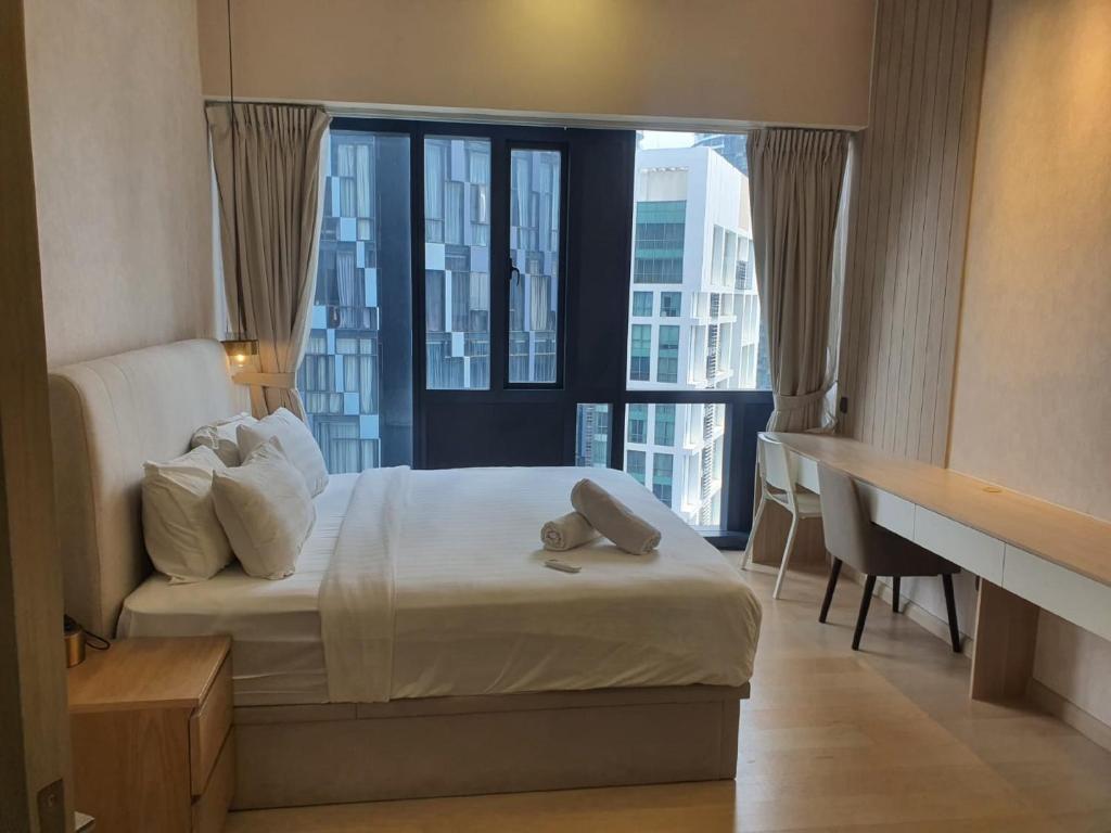 um quarto de hotel com uma cama e uma grande janela em KLCC Ritz Residence STAR em Kuala Lumpur