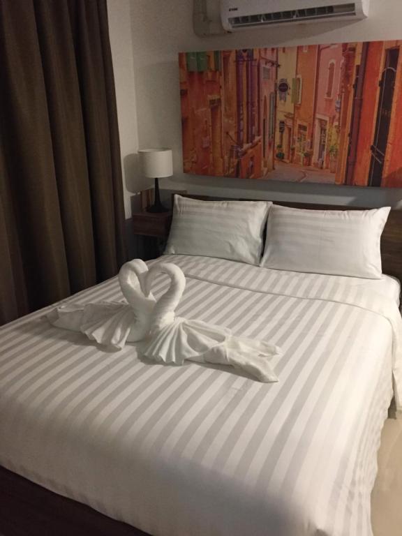 łóżko z dwoma łabędzie wykonanymi z ręczników w obiekcie Mai Khao Beach Apartments w mieście Ban Bo Sai Klang