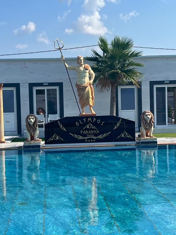 a statue of a woman standing next to a swimming pool at Paradice Hotel Luxury Suites-Near zorbas Beach-FREE Breakfast in Stavros