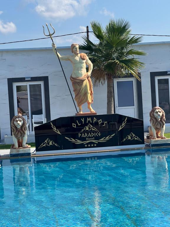 a statue of a woman standing on a sign next to a swimming pool at Paradice Hotel Luxury Suites-Near zorbas Beach-FREE Breakfast in Stavros