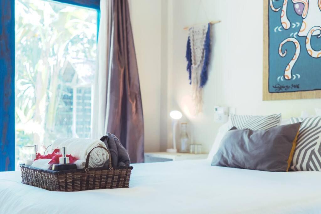 una camera con un letto con un orologio e una finestra di Sleepy Gypsea Villa Siargao - Private Room - Daydream a Catagnan