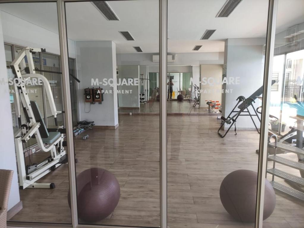 einen Fitnessraum mit Glastüren und ein Fitnesscenter in der Unterkunft Apartemen Msquare Cibaduyut 23 m studio in Bandung