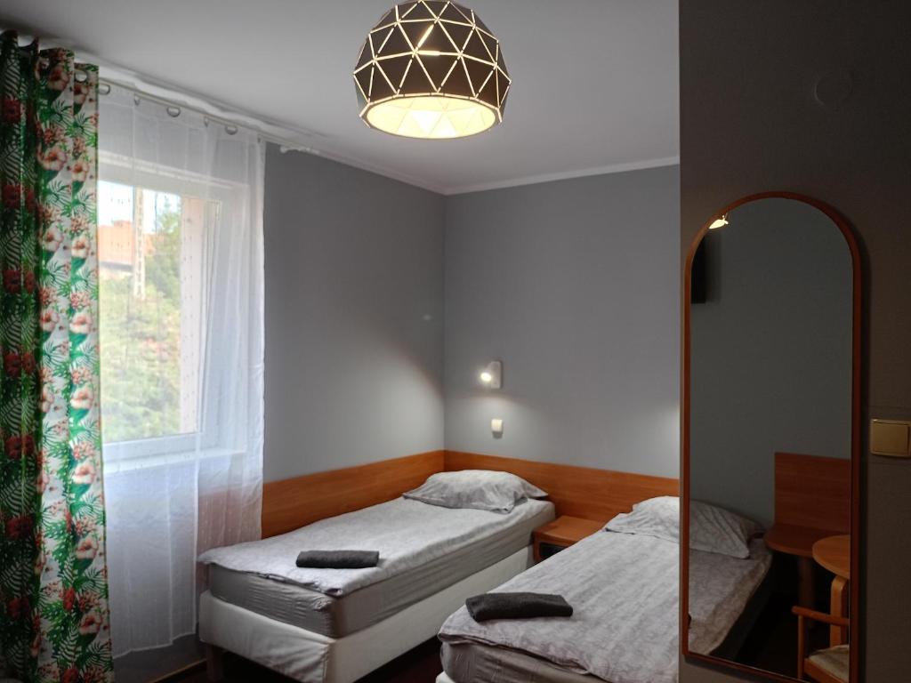 a small room with two beds and a mirror at ZAJAZD Wałbrzych in Wałbrzych