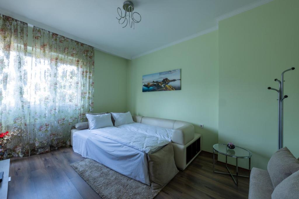 una camera da letto con un letto e un divano di Julie Suite Top Center a Sofia