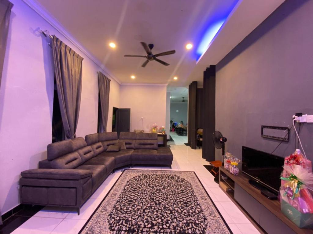 - un salon avec un canapé et un ventilateur de plafond dans l'établissement homestay kuala kedah, à Kuala Kedah