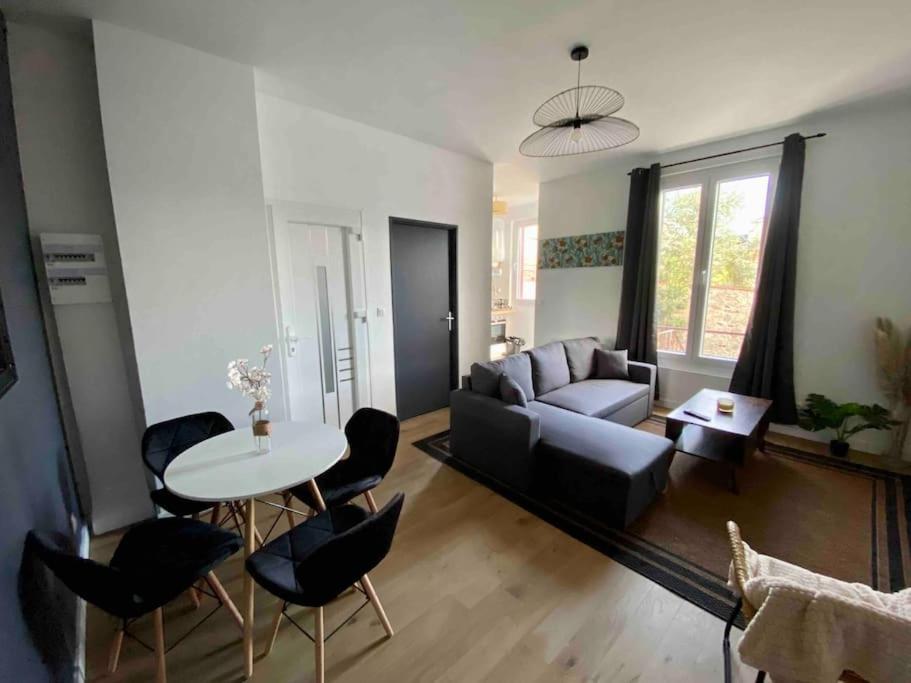 un salon avec un canapé, une table et des chaises dans l'établissement Centre de Vichy avec terrasse, à Vichy