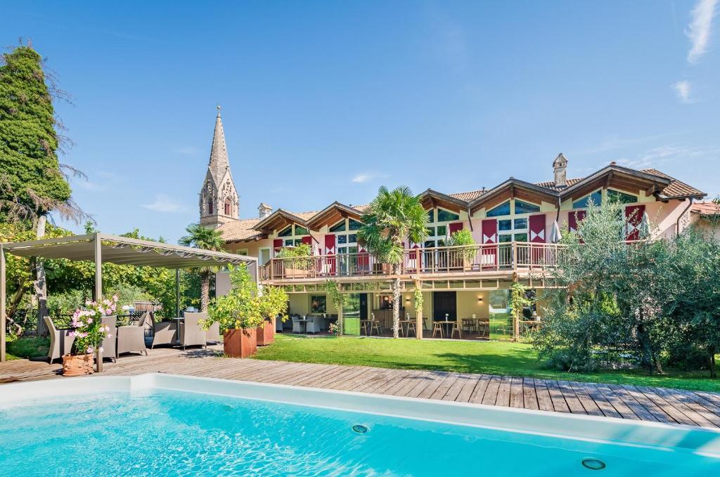 une grande maison avec une piscine en face de celle-ci dans l'établissement Gartenheim Tramin, à Termeno