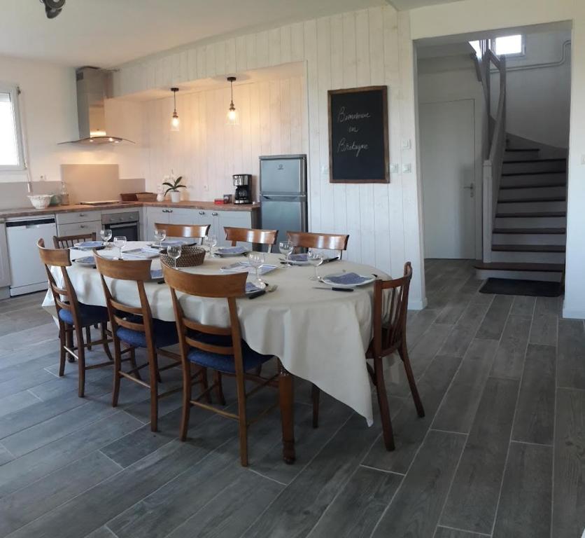 ein Esszimmer mit einem weißen Tisch und Stühlen in der Unterkunft Gîte breton au bord du GR34 in Landunvez