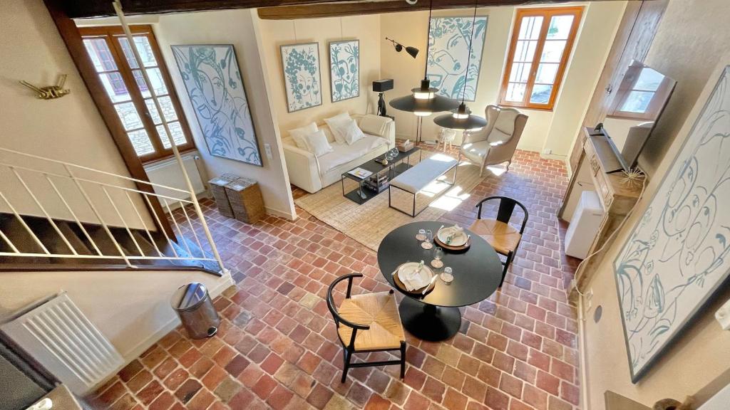 een woonkamer met een tafel en stoelen bij La Dolce Vita in Beaune