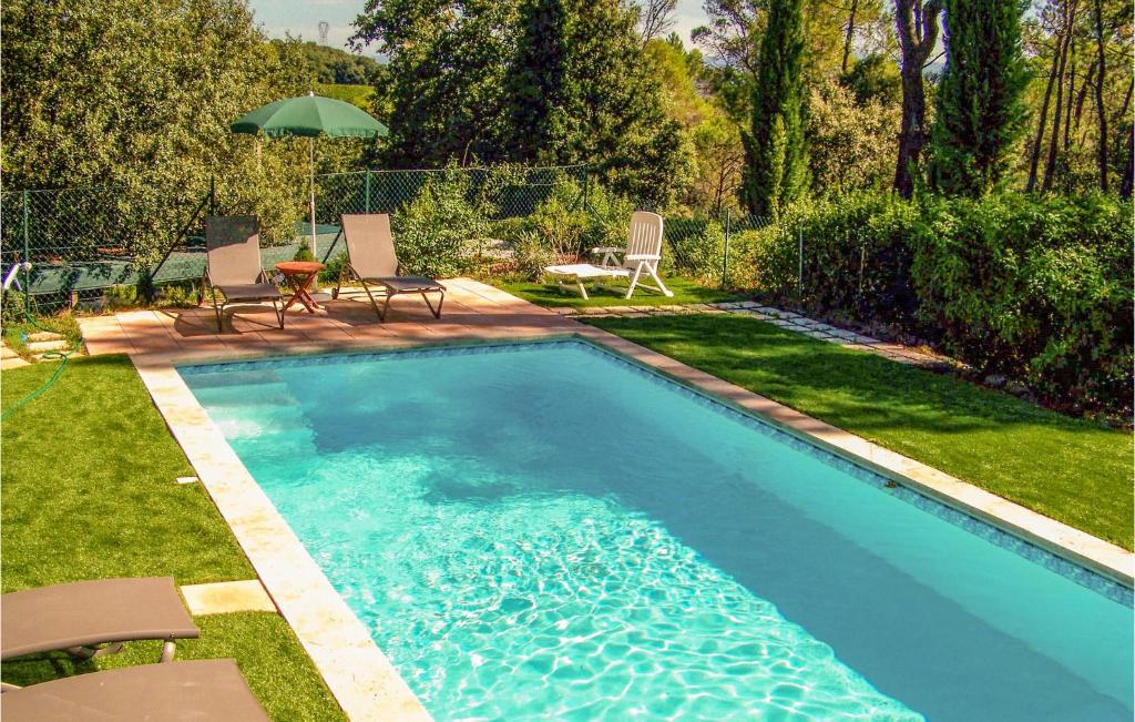 - une piscine avec des chaises et un parasol dans la cour dans l'établissement Beautiful Home In Mondragon With Kitchen, à Mondragon