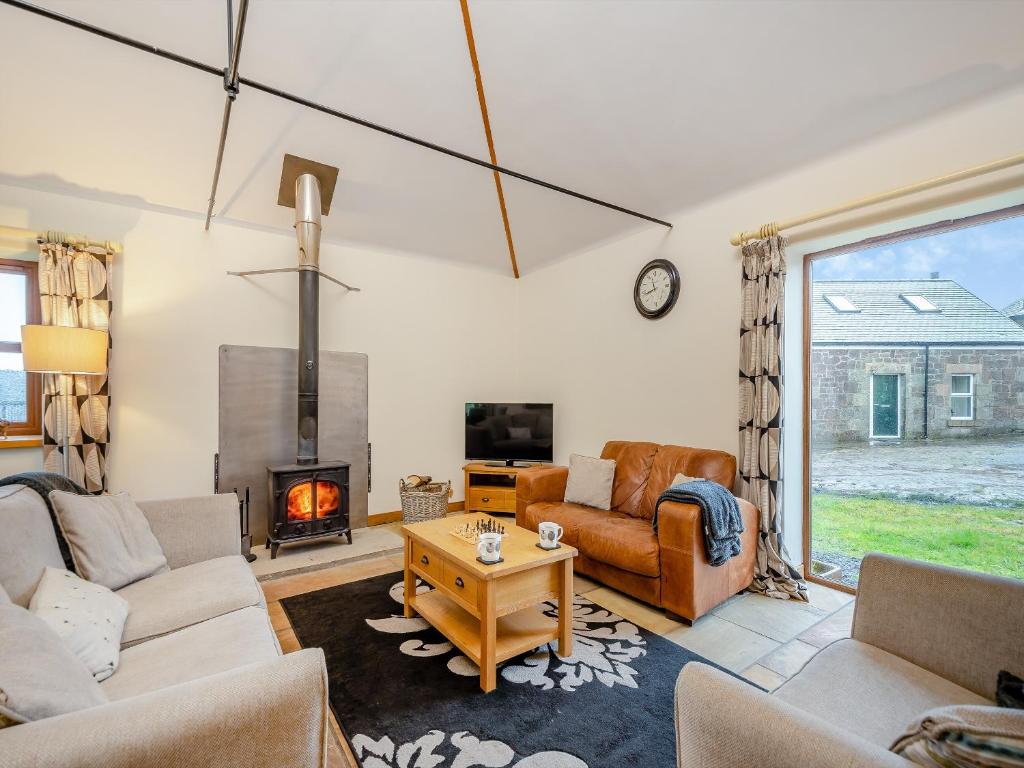 a living room with a couch and a fireplace at South Steading in Seamill