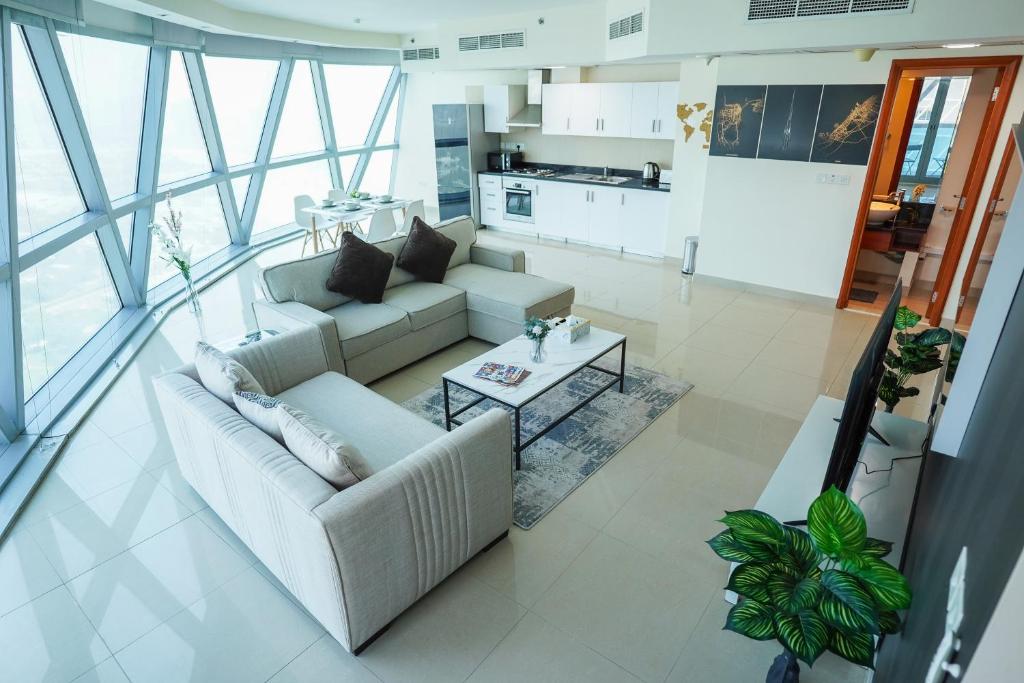 una sala de estar con 2 sofás blancos y una mesa. en DIFC Luxurious Spacious 1-Bed Apt in a Prime Location, en Dubái