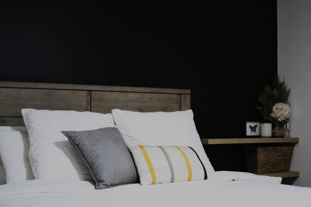 een slaapkamer met een bed met witte lakens en kussens bij Gum Lodge, Gateway to the Murray in Loxton