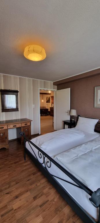 ein Schlafzimmer mit einem großen Bett und einem Schreibtisch in der Unterkunft Drachenburg in Marktbreit