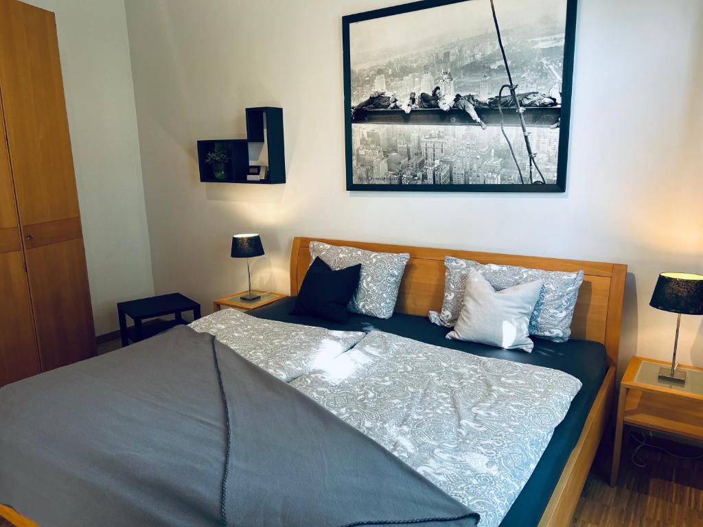 Schlafzimmer mit einem Bett mit blauer Bettwäsche und Kissen in der Unterkunft Schlosspark Apartment I 80qm I 3 Betten I bei Pirna in Heidenau