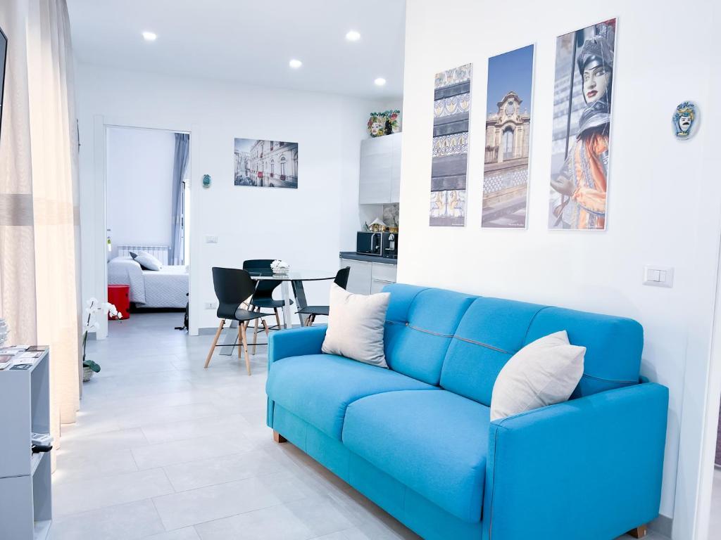 a blue couch in a white living room at Appartamento al centro storico in Caltagirone