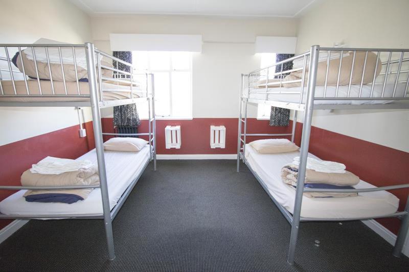 2 Etagenbetten in einem Zimmer mit roten Wänden in der Unterkunft Dormitory Pension Sofas Bunk Bed Rooms in Homestay Apartment in Antalya