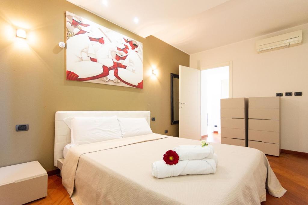 een slaapkamer met een groot wit bed en handdoeken bij Assago amazing flat in Assago
