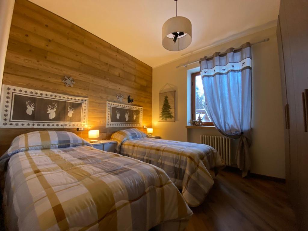 a bedroom with two beds and a window at Ca' di Crös in Frabosa Soprana