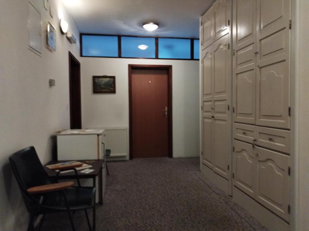 a locker room with a door and a chair and a table at Prenoćište San Rooms in Livno