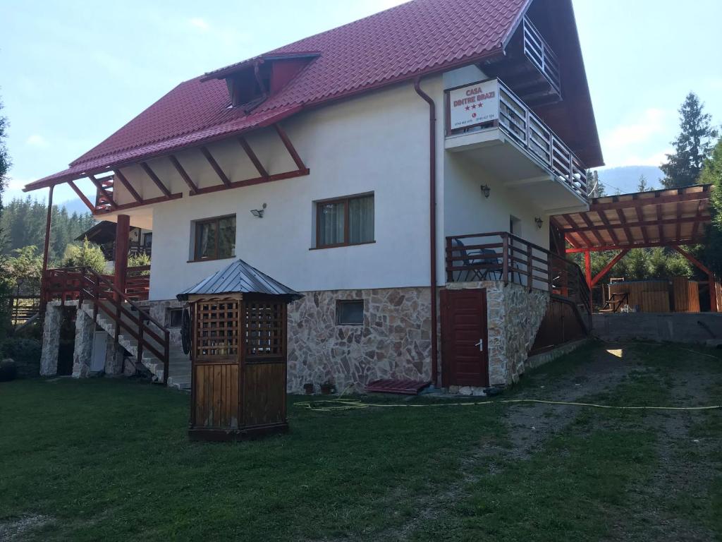 ein großes weißes Haus mit rotem Dach in der Unterkunft Casa dintre Brazi in Arieşeni