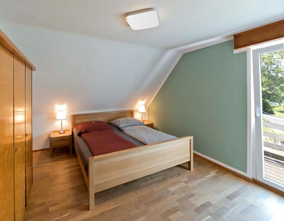 a bedroom with a bed and a large window at Cozy Inn Schladern in Windeck
