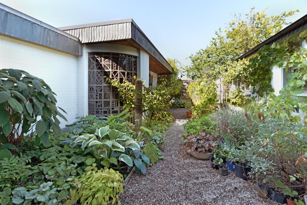 a garden next to a house with plants at Cozy Inn Schladern in Windeck