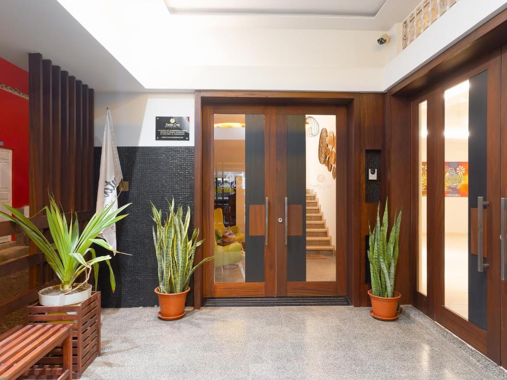 a lobby with wooden doors and potted plants at Santa Cruz Boutique Hotel in Mindelo