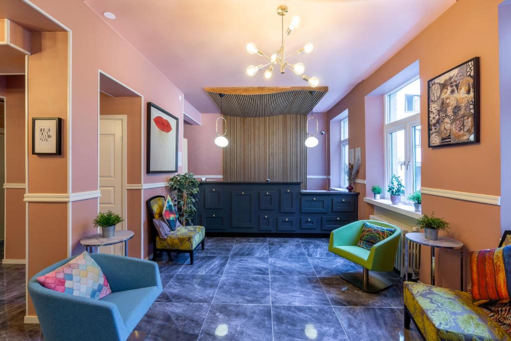 a lobby with chairs and tables and a chandelier at City Hotell Avenyn in Gothenburg