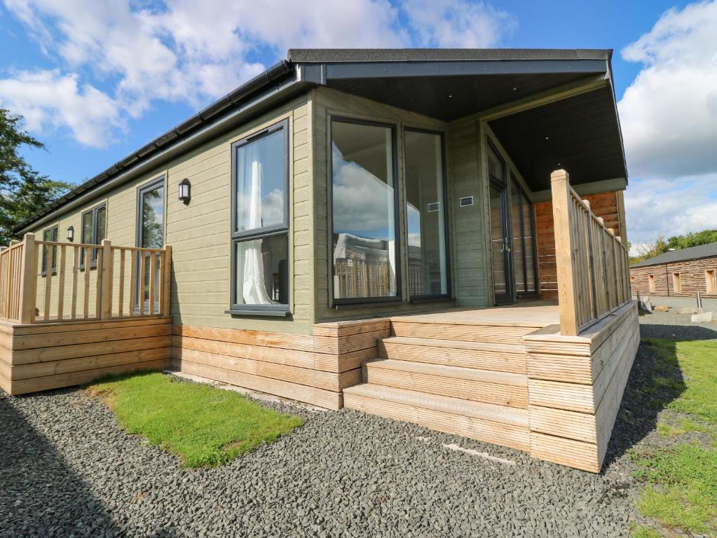 a tiny house with a porch and a deck at Lodge 15 - The Tummel Family in Perth