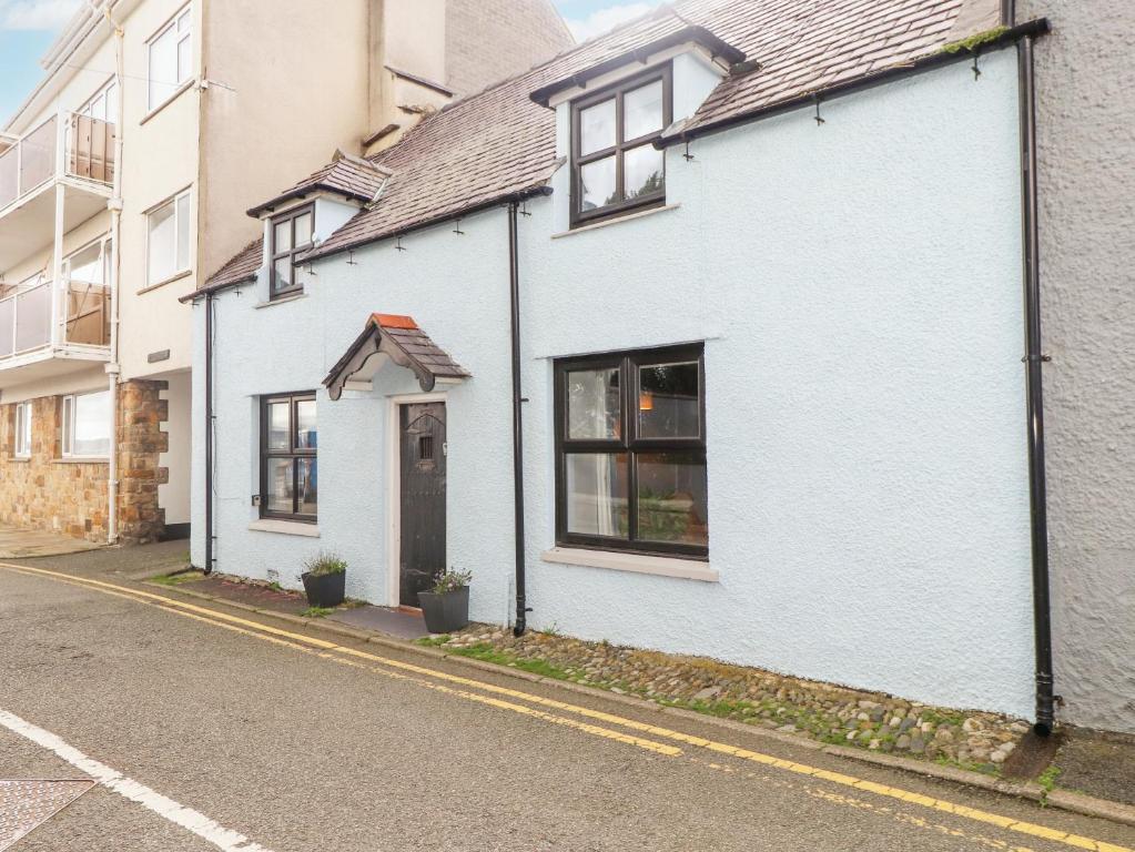 una casa blanca al lado de una calle en Ewyn Y Mor en Beaumaris