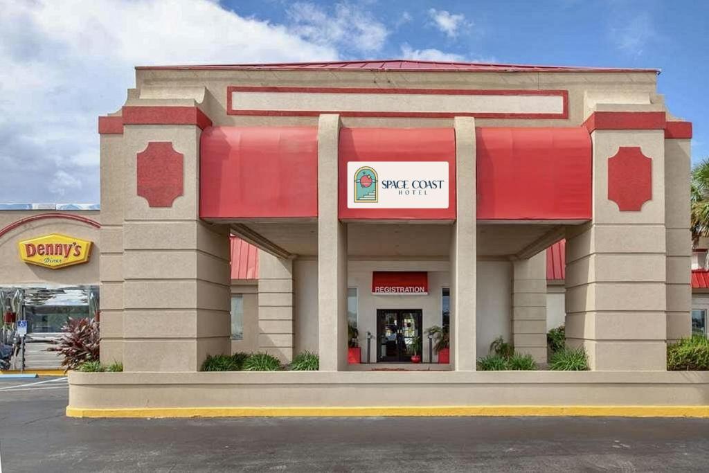 un magasin Walmart avec un auvent rouge dans un parking dans l'établissement Space Coast Hotel Titusville-Kennedy Space Center, à Titusville