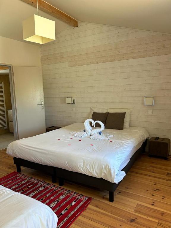 une chambre avec un lit avec un cygne dessus dans l'établissement Centre de bien-être Le Miel et l'Eau, à Clermont-Dessous