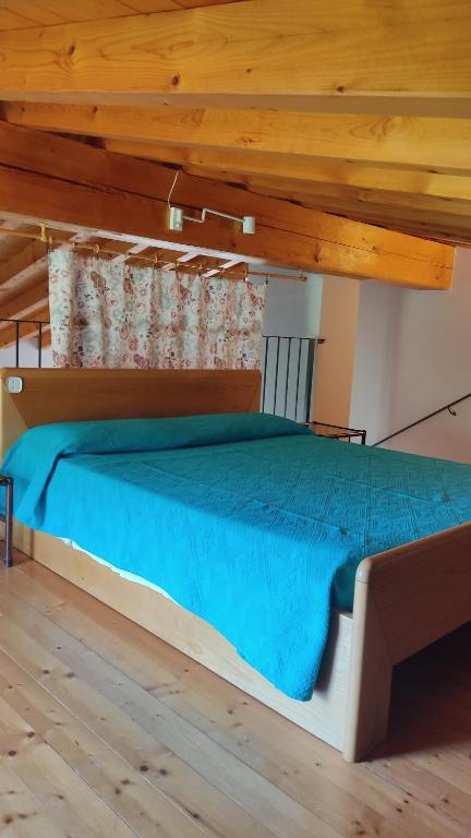 Cama grande en habitación con techo de madera en Appartamento Cristol, en Gargnano