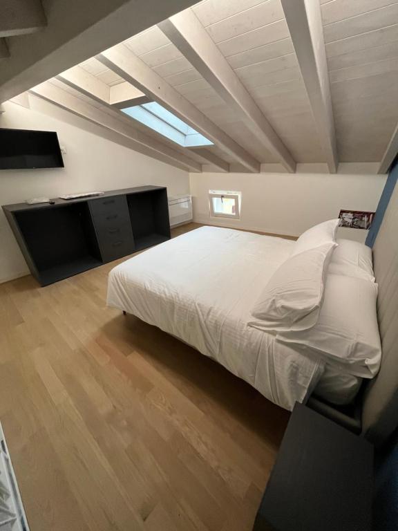 1 dormitorio con 1 cama grande y TV en La Casa Incartata, en Toscolano Maderno
