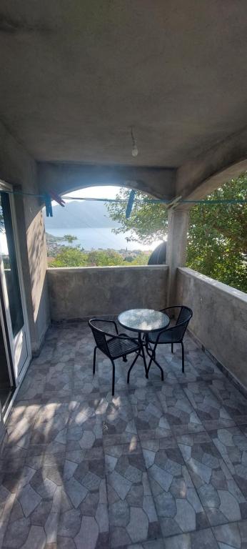 un patio con una mesa y un banco en un porche en Samardzici, en Risan