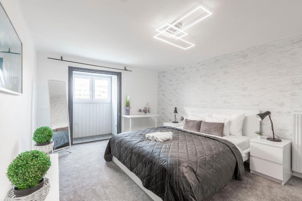 1 dormitorio con 1 cama grande en una habitación blanca en Deluxe Quentin Apartment next to the Heroes Square, en Budapest