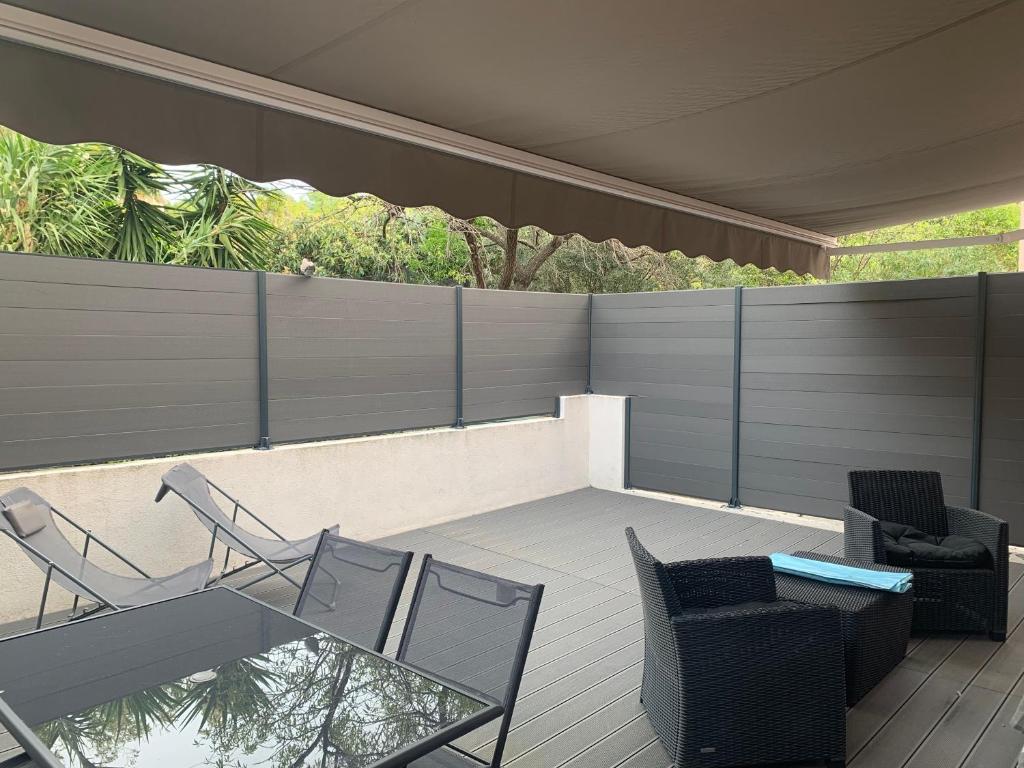 un patio avec des chaises et une table et une clôture dans l'établissement Cassis grande terrasse emplacement au top à 1 minute de la plage à pieds, à Cassis