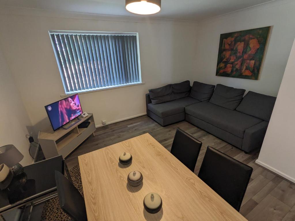 sala de estar con mesa y sofá en Kijivu Suites 2 Bedroom Apartment en Bradford