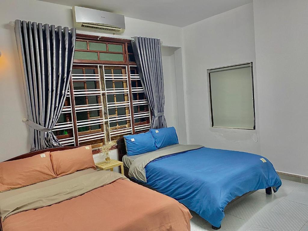 a room with two beds and a window at Shine Riverside Homestay in Hue