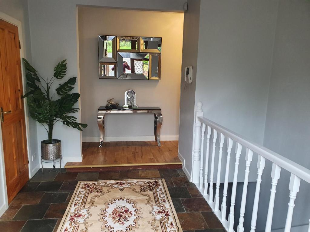un pasillo con una escalera con una mesa y una planta en Hillcrest House, en Carrick on Shannon