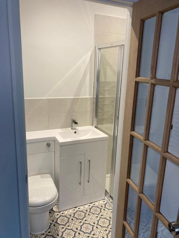 e bagno con servizi igienici, lavandino e doccia. di En-suite room near a Cardiff