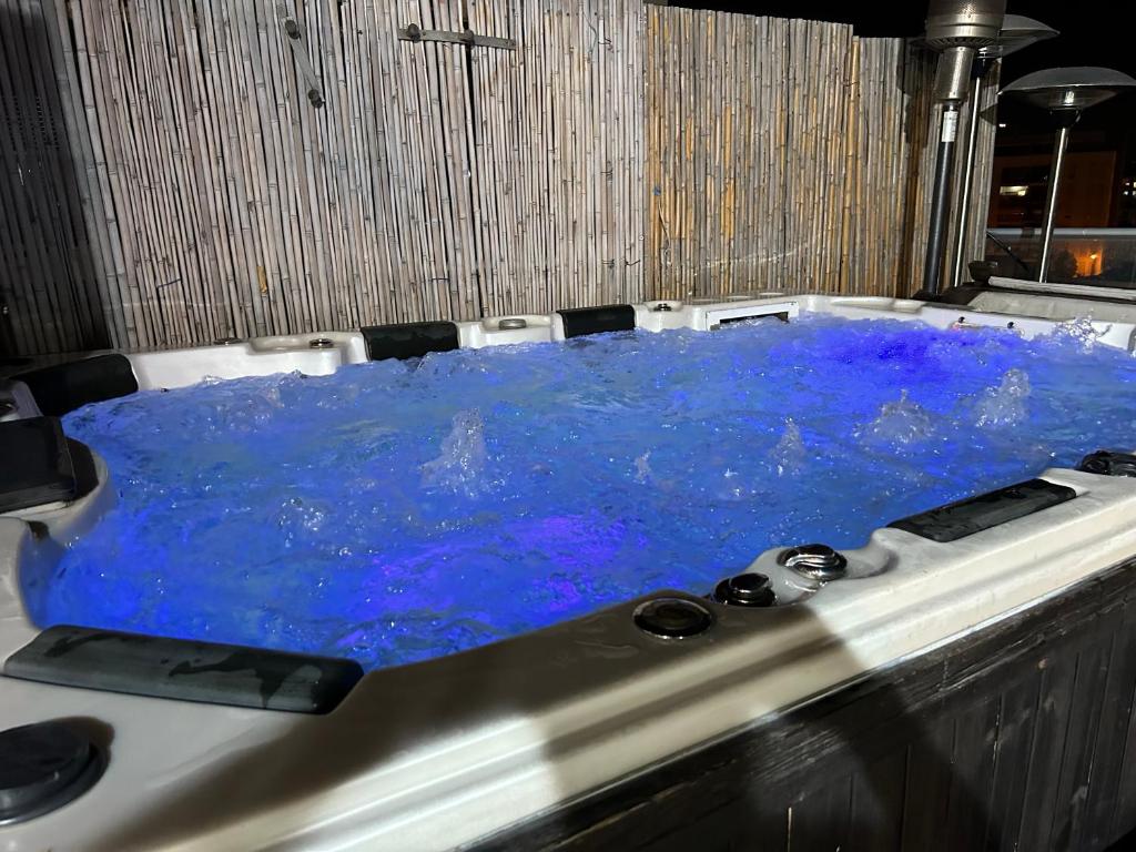 a hot tub filled with blue water in a room at Suite 24/7-סוויטת 24/7 in Ramat Gan