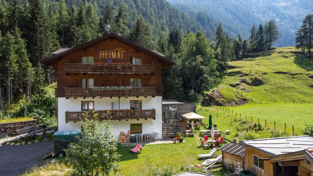 a hotel with a balcony in a mountain at Heimat - Das Natur Resort in Prägraten am Großvenediger