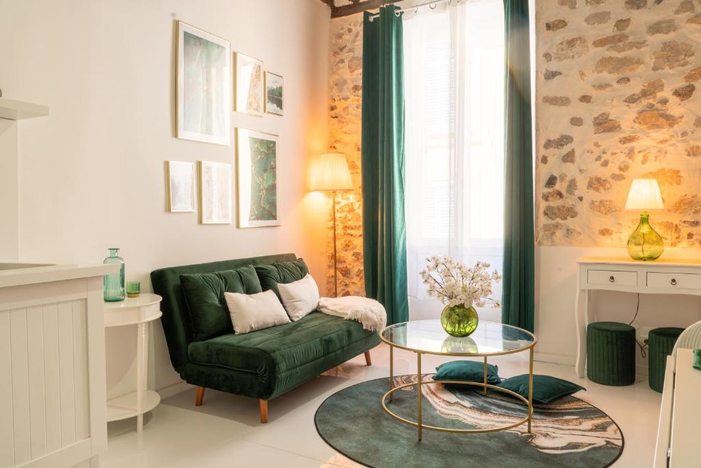 a living room with a green couch and a table at Le Cosy Safranier Vieil Antibes in Antibes