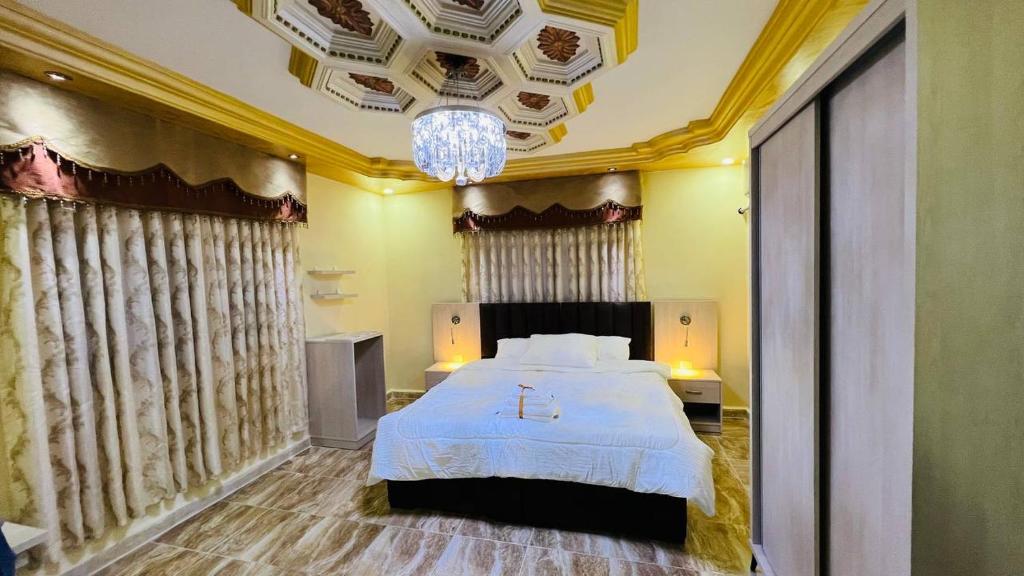 a bedroom with a bed and a chandelier at Petra Glamour Hostel in Taiyiba