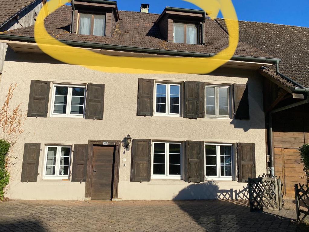 une maison avec un grand cercle jaune sur son côté dans l'établissement Ruhige 2 Zimmer Wohnung, à Diegten