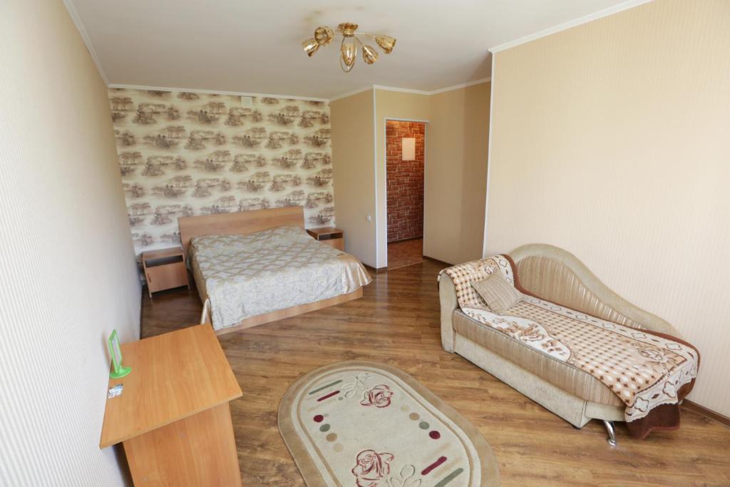 1 dormitorio con cama, sofá y mesa en Строймарт, en Petropavlovsk