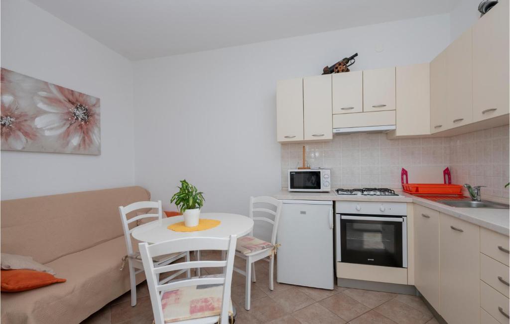 a small kitchen with a table and a couch at Cozy Home In Makarska With Kitchen in Makarska