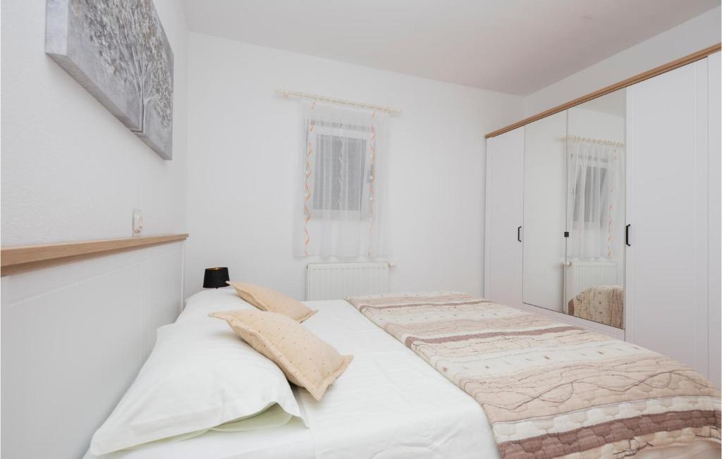 a white bedroom with a large bed with white walls at Cozy Home In Makarska With Kitchen in Makarska
